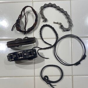 7 Assorted Black and Brown Bracelets with one bike chain style bracelet.